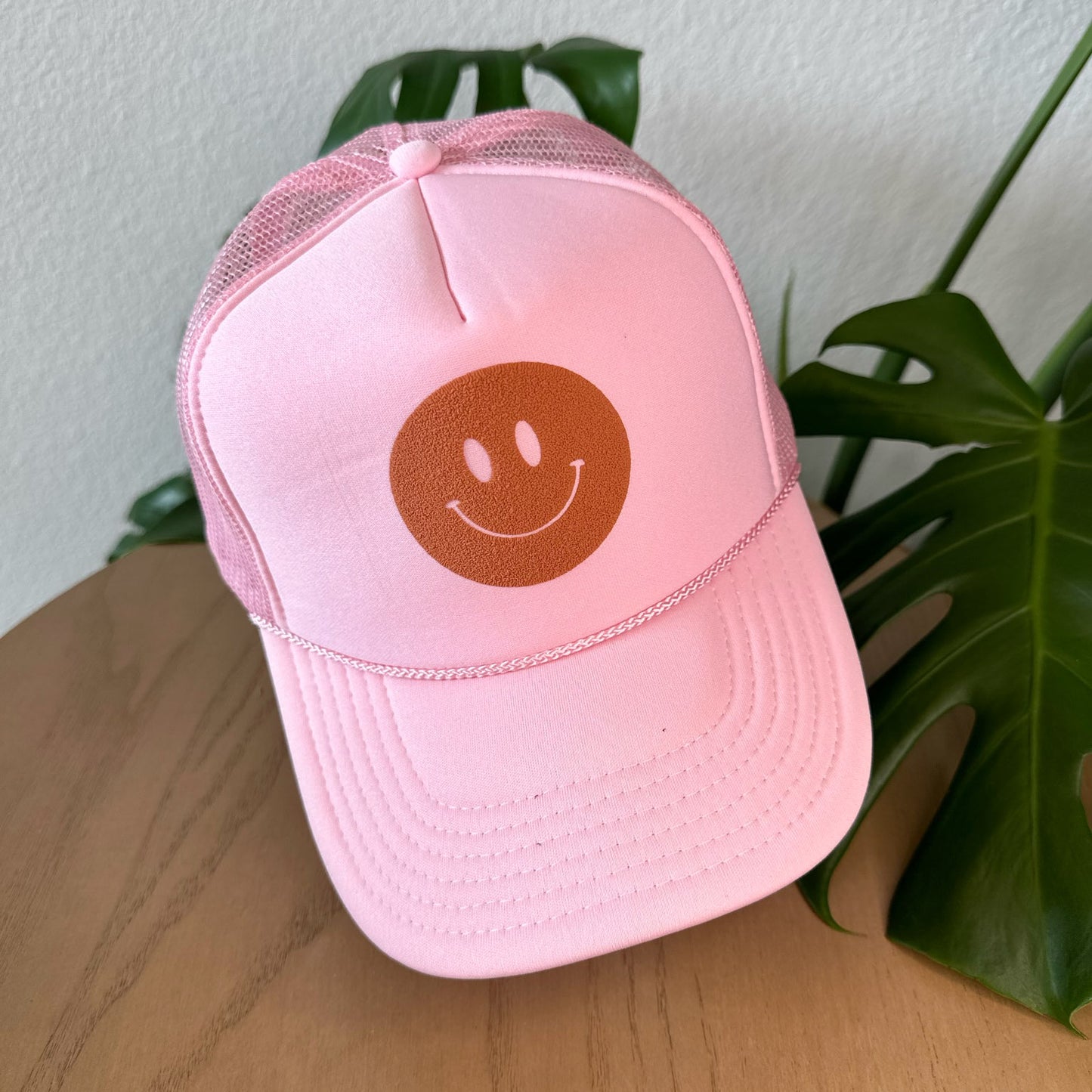 the trucker - rust smiley on light pink